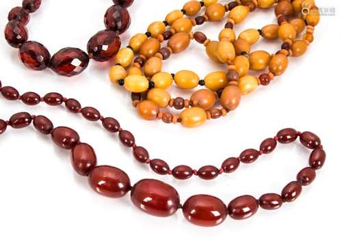 A collection of amber beads, including two strings of toffee coloured oval examples alternately