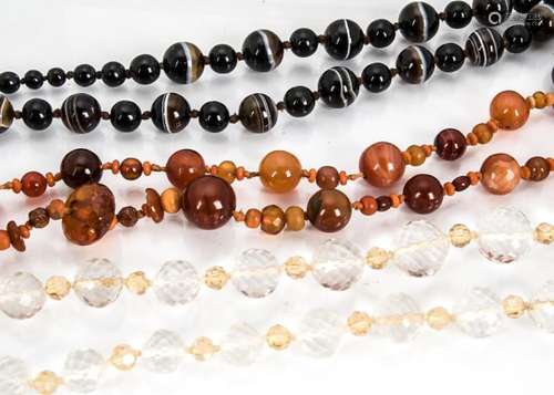 A collection of hardstone beads, including bullseye agate, rock crystal, and carnelian