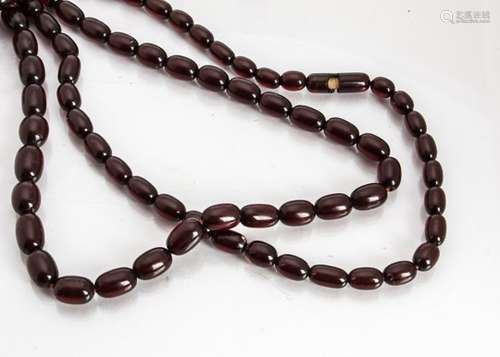 A string of simulated cherry amber beads, the uniform oval beads with screw clasp (af) on red