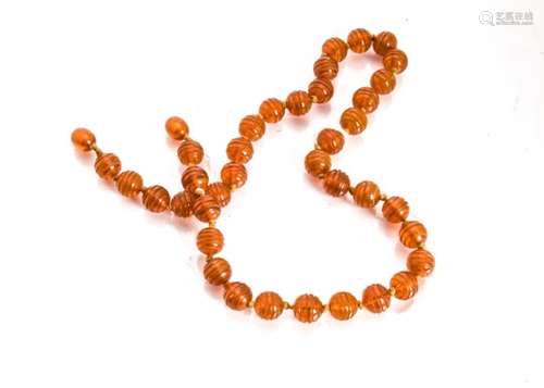 A string of Baltic amber worked beads, the banded, knotted strung necklace with screw clasp, now af,