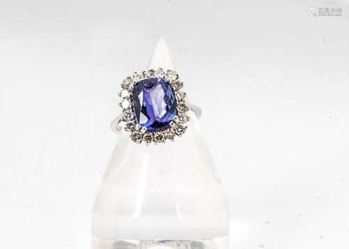 A tanzanite and diamond 18ct gold cluster ring, the large step cut tanzanite in a four claw