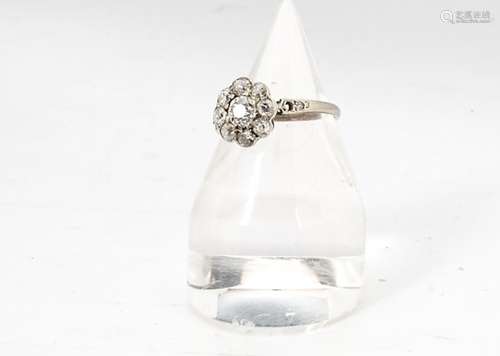 An Edwardian style diamond flower head ring, the central old cut diamond surrounded by eight old cut