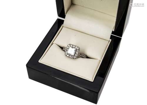 A certified diamond engagement ring, the princess cut central diamond surrounded by a bezel of