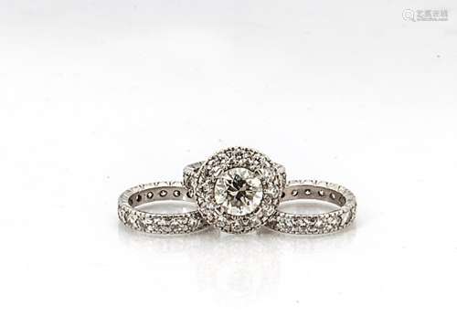 A custom made diamond set solitaire ring and two matching diamond encrusted eternity bands, the