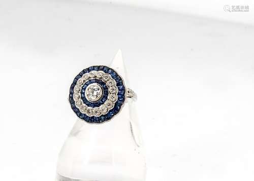 A sapphire and diamond Art Deco style target ring, centred with an old cut rubbed over set