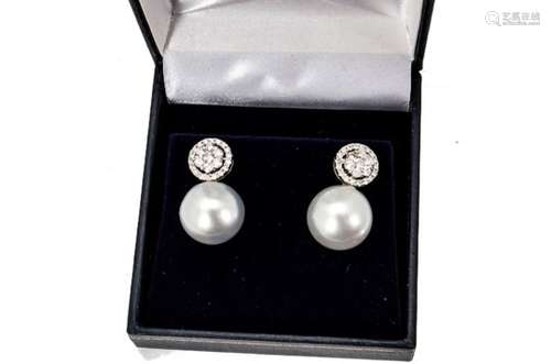 A pair of diamond and cultured pearl ear studs, the diamond cluster studs supporting large