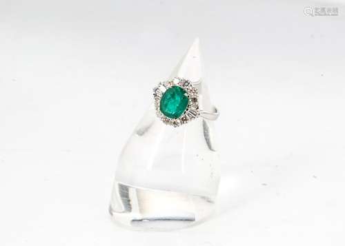 An emerald and diamond Art Deco style dress ring, central oval cut emerald in four claw setting