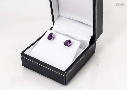 A pair of oval mixed cut amethyst ear studs, in box