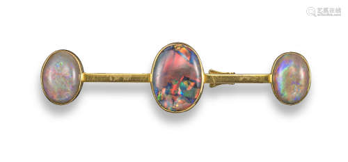 A gold brooch set with three oval-shaped opals