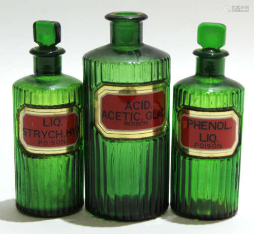 Group of green glass apothecary bottles, the reeded bodies with an inset 