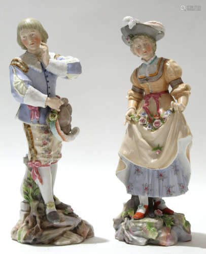 Continental porcelain model of a man and a lady on rockwork bases, 25cm high