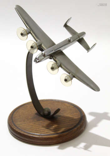 Metal model of a Lancaster bomber, the propellers modelled in plastic, mounted on a circular