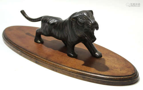 Spelter model of an Asiatic lion or tiger, on oval wooden base, the model 30cm long