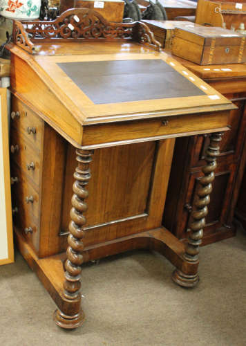 19th century rosewood Davenport with scroll carved fretwork pediment, lifting lid below enclosing