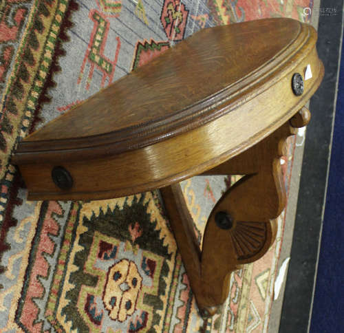 Early 20th century oak console table of demi-lune form with pierced support, 67cm wide