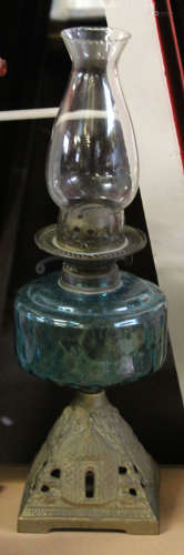 Late 19th century oil lamp with metal shaped foot and green glass reservoir, 50cm high