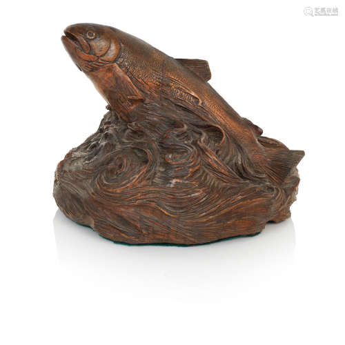 A carved wooden salmon sculptureDepicting a salmon rising from a circular base of scrolling waves, signed 'T.D'