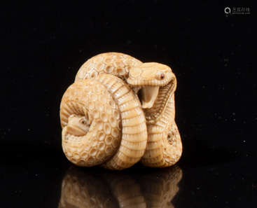 Netsuke en ivoire représentant un serpent enroulé …