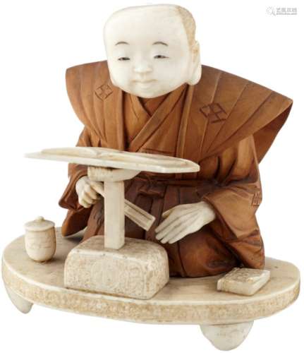 OkimonoJapan um 1920. Elfenbein und Holz. Kniender junger Mann beim Lesen. Plinthe mit Signatur