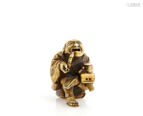 A stained ivory netsuke of a seated man, smoking a pipe whilst holding a sagemono in his left