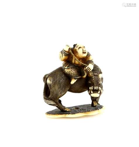 An ivory netsuke of a boy seated on a water buffalo; the base with a single himotoshi; signed