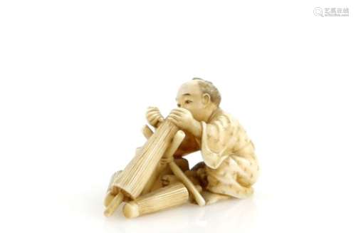 A stained ivory okimono of an umbrella or parasol maker, 5cm long, Meiji PeriodProvenance: The