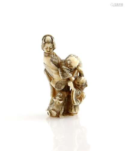 A stained ivory netsuke carved as a standing Yamato Nadeshko with two children and a dog, signed