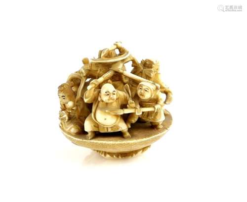 An okimono style netsuke of the Shichifukujin in a massive sakazuki; the himotoshi on the base of