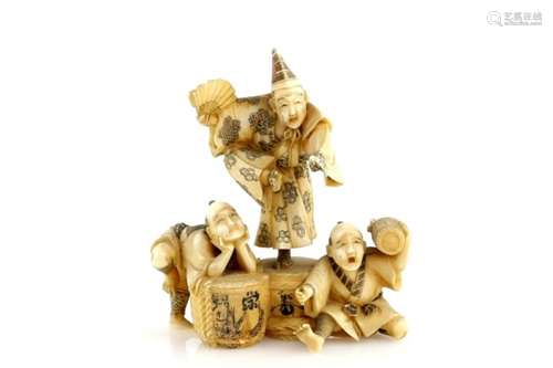 A stained ivory okimono carved as a Manzai, or other, dancer on top of a Sake jar beside two other