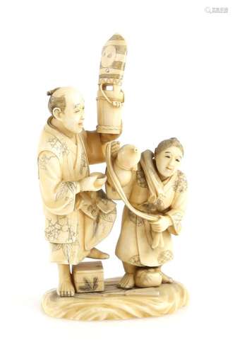 A sectional ivory okimono of a standing man and his son, the man holding aloft a Sambaso Dancer's