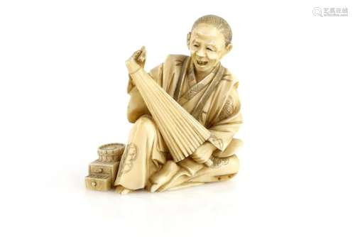 A stained, sectional ivory okimono of an umbrella and parasol maker, 9 cm high, Meiji