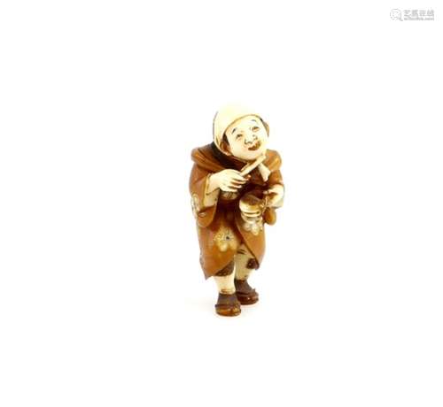 A stained ivory netsuke of a standing pilgrim beating a suzu, signed ShuzanProvenance: The