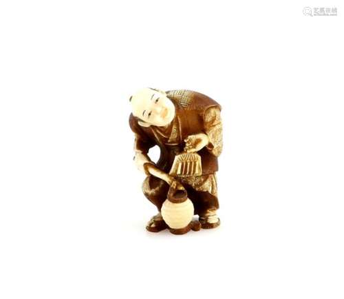 A stained ivory netsuke of a bird scarer holding a lantern with his left hand, signed Kogyoku,