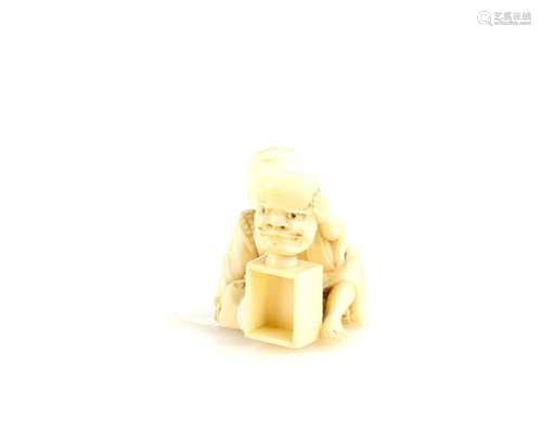 An ivory netsuke of a boy holding up a mask on a box, 19th CenturyProvenance: The Property of a