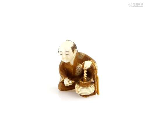 A stained ivory netsuke carved as a seated Lantern Maker, signed Kogyoku, 20th CenturyProvenance: