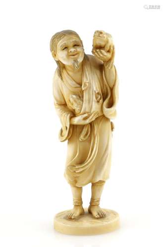 A stained ivory okimono, carved as a standing figure of Gama Sennin holding a magic toad with his