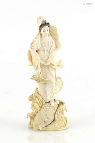 A small stained ivory okimono of Benten emerging from the waves beside a large carp, 9.5 cm high,