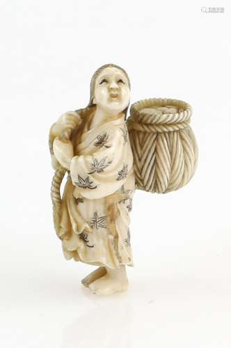 A small ivory netsuke carved as a standing girl holding a basket on her back, signed Gyokusai,