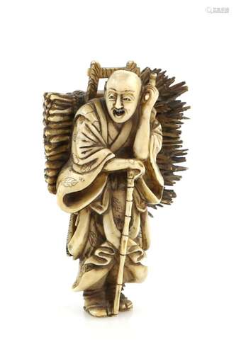 A stained ivory okimono carved as a standing wood collector, carrying a large bundle on his back