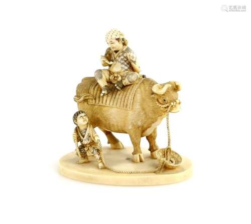 A stained ivory okimono carved as a farmer with his pipe on the back of a large ox being led by a