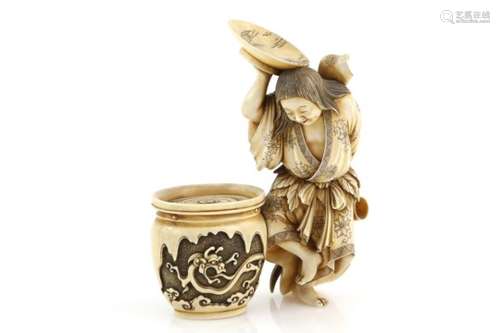 A stained ivory okimono carved as a dancing Shojo holding a large sakazuki above her head and a