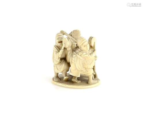 An okimono style ivory netsuke with central himotoshi, carved as group of dancers and musicians,