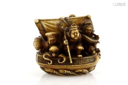 A heavily stained ivory netsuke carved as The Takarabune carrying five of The Shichifukujin;