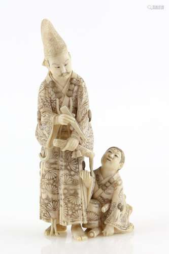 A stained ivory okimono of a standing scholar with his acolyte or son, 13 cm high, 20th