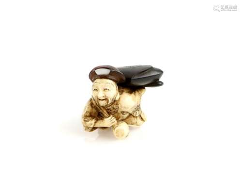 A stained ivory and wood netsuke carved as Daikoku carrying a large tobacco pouch, the lucky