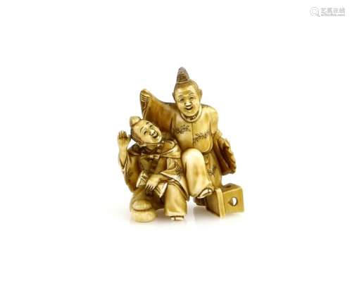 A stained ivory netsuke of two Manzai Dancers, one playing a tsuzumi; 19th or 20th