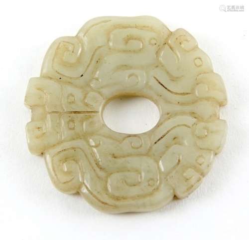 A Chinese green jade disc carved with stylised dragons, 4.5cm diameter, post Qing Dynasty .