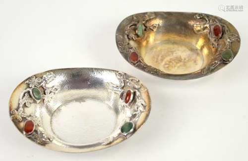 Pair of Chinese white metal oval dishes with cabochon stone inlaid decoration .