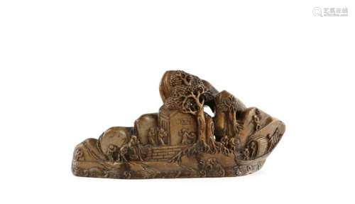 A Chinese soapstone brush rest, carved with scholars and figures beside a coastal building; 23 cm