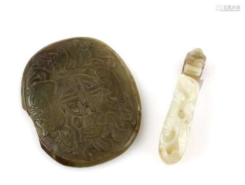 A mottled green jade belt hook of typical curved form with reverse boss and animal head, 7.5 cm